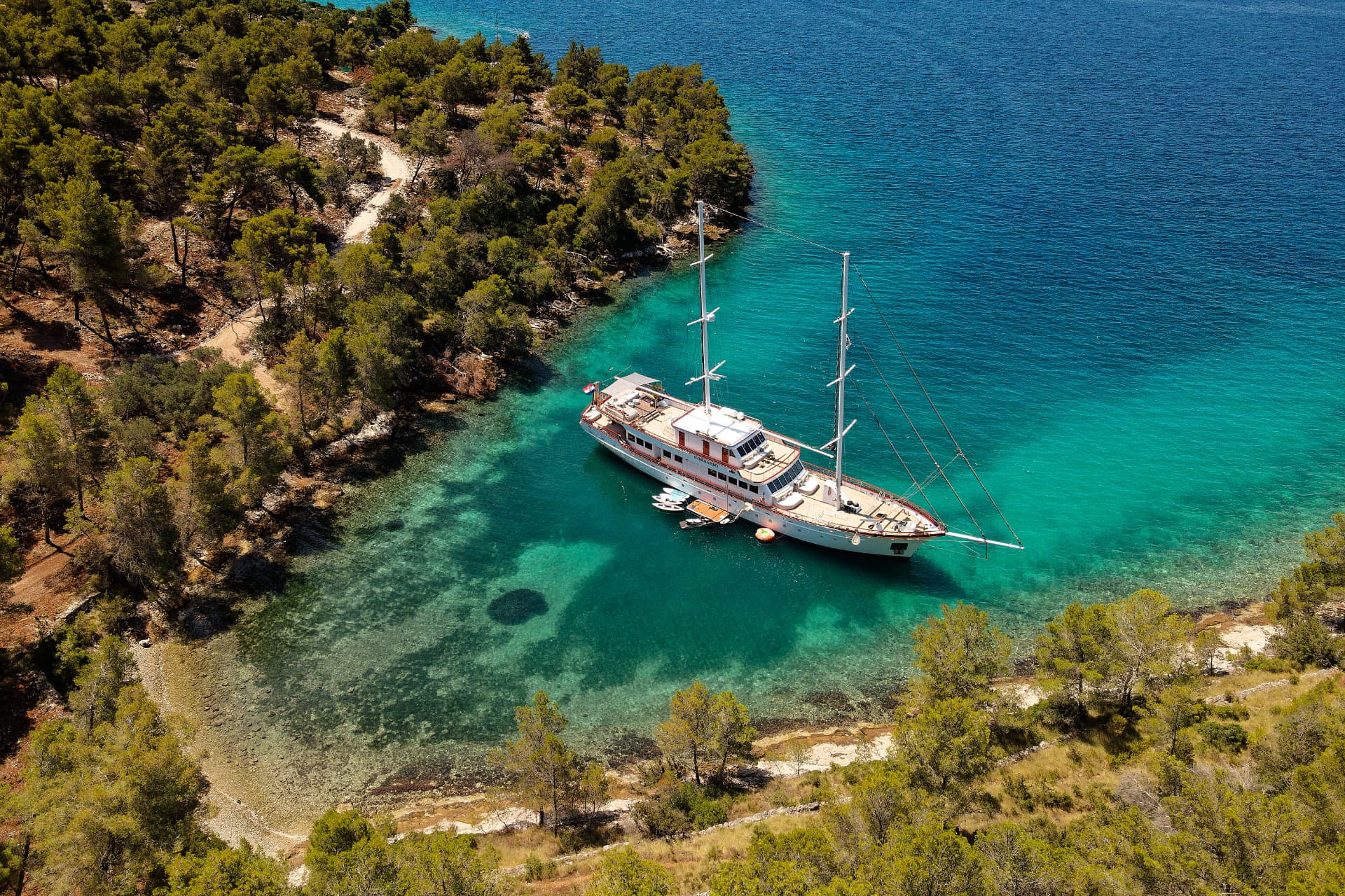Corsario anchored in a turquoise Croatian cove, aerial view