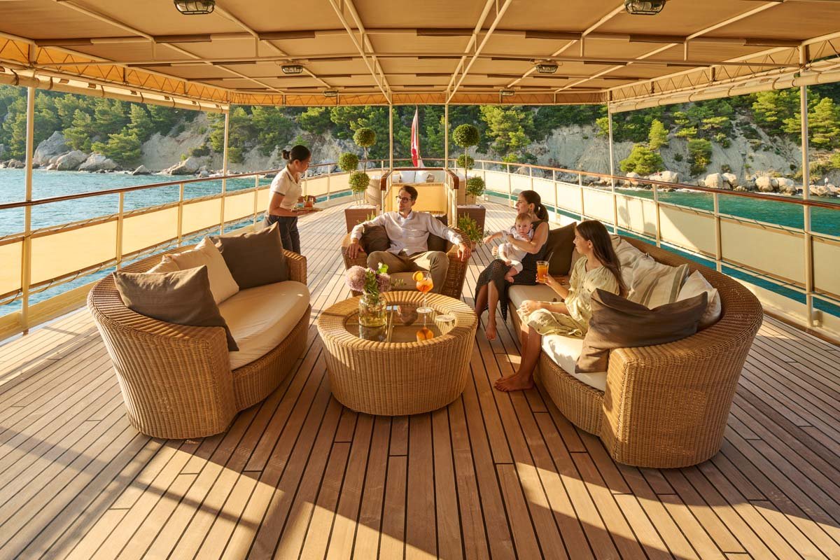 Guests relaxing in Seagull II's shaded aft deck lounge