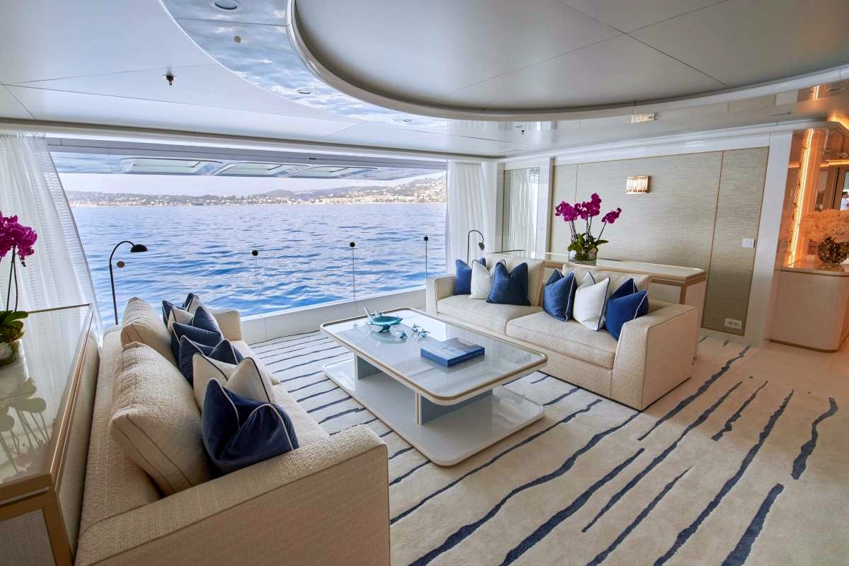 Coral Ocean's main saloon in chalk white and marine blue, opening onto the sea. Photo: Coral Ocean