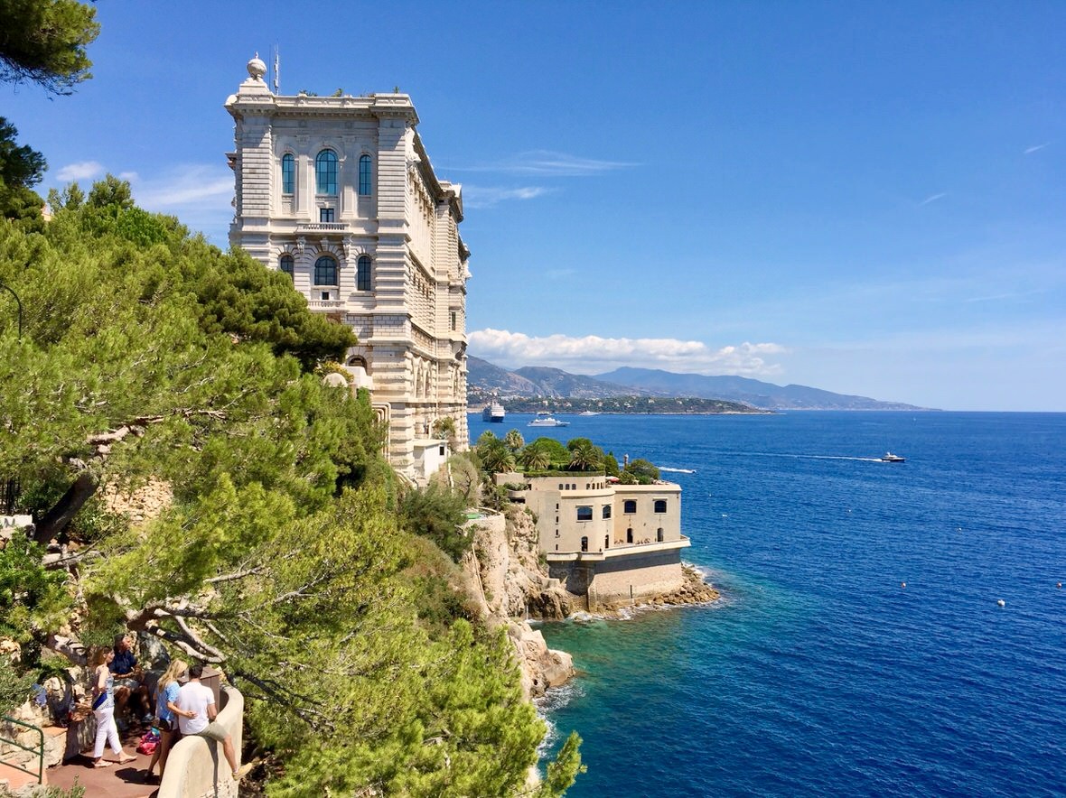 The Oceanographic Museum on its cliff above the deep blue sea, pines in the foreground