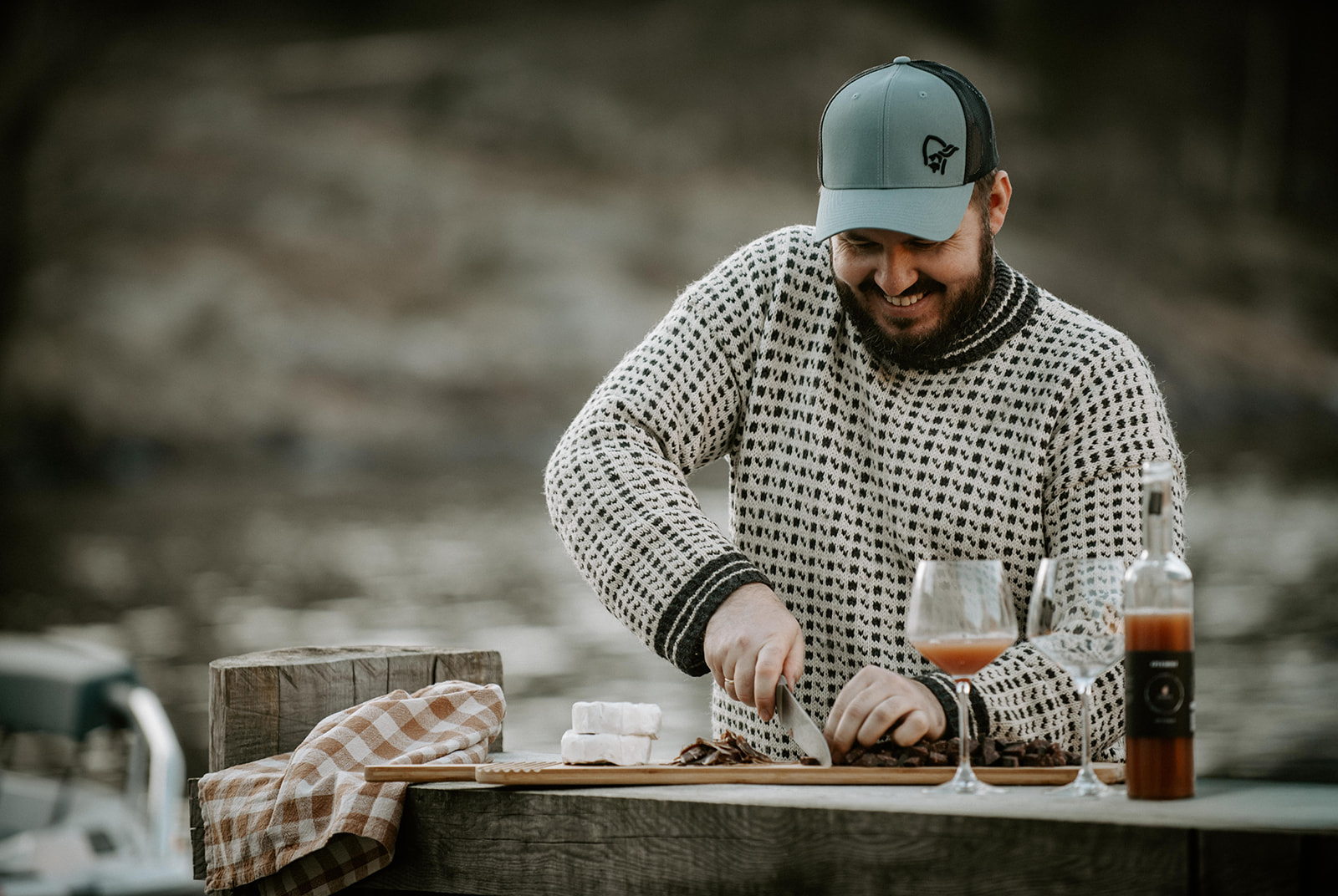 A local chef preparing food beside a Norwegian fjord