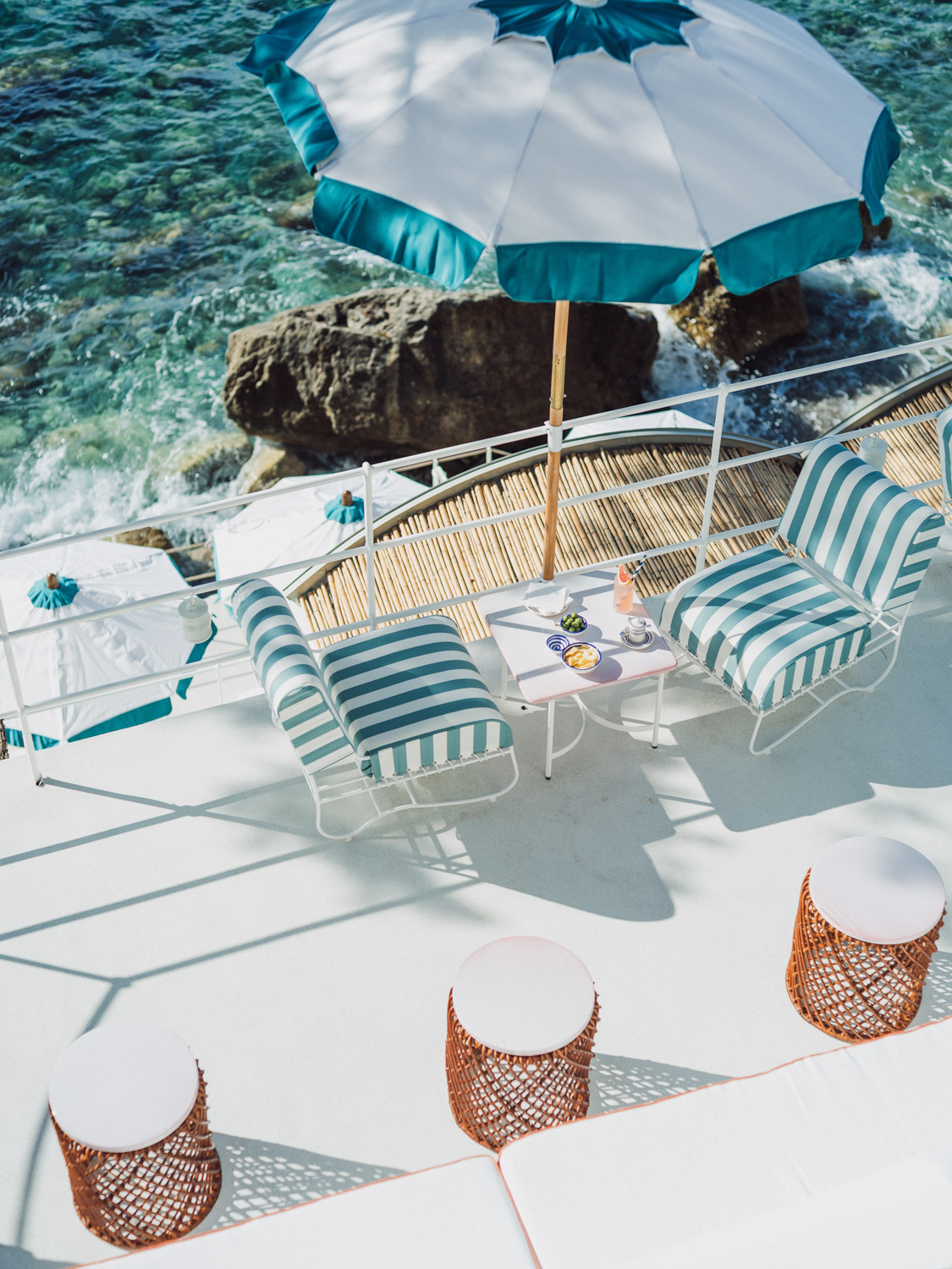 Striped chairs and parasols above the sea at Rose's Bar