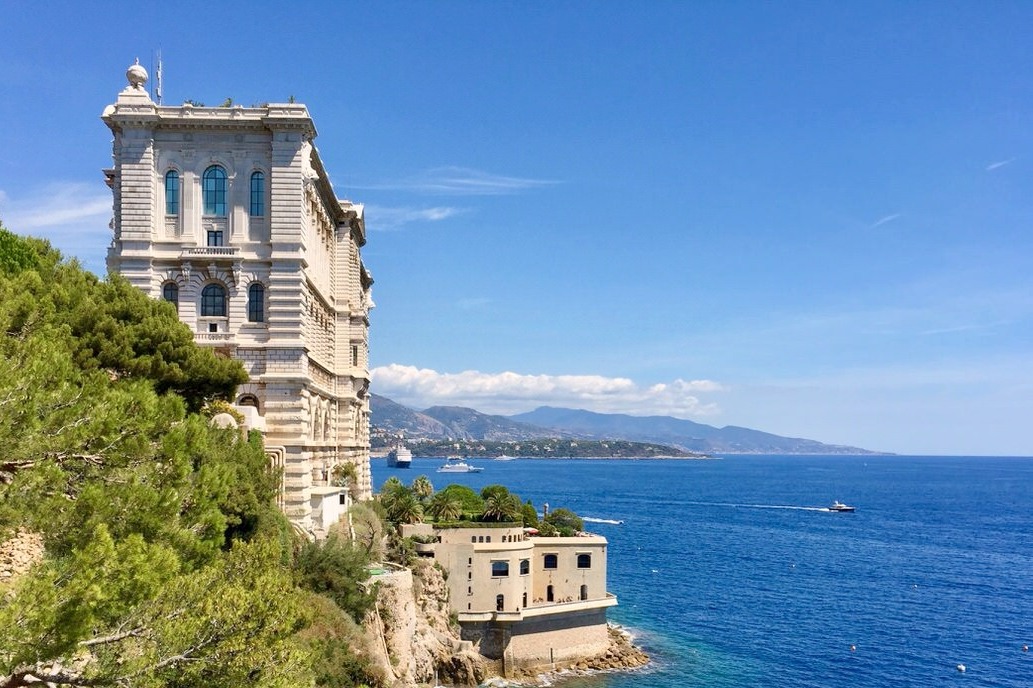 The Oceanographic Museum on its cliff above the deep blue sea, pines in the foreground
