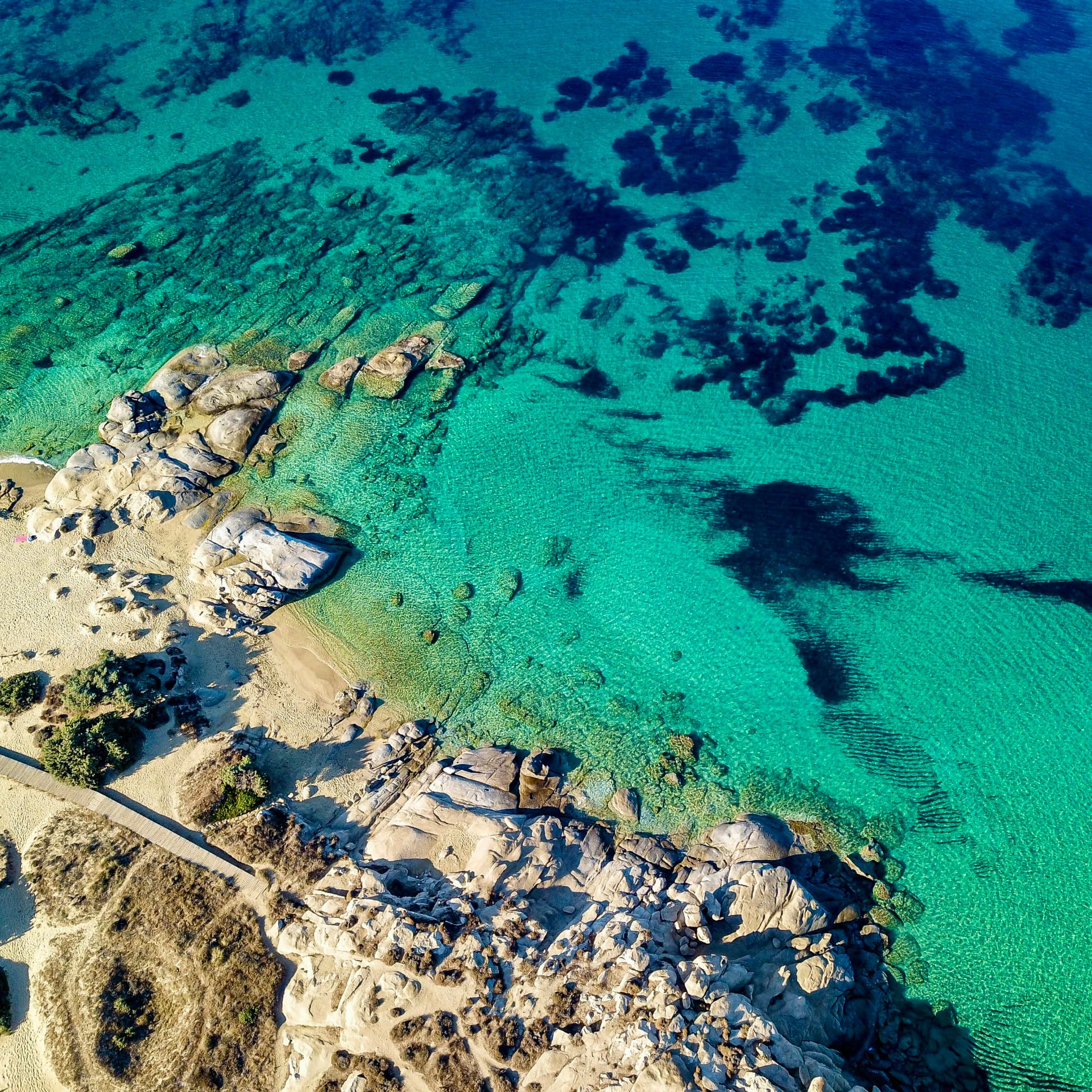 The turquoise coast and rocky coves of Naxos from the air