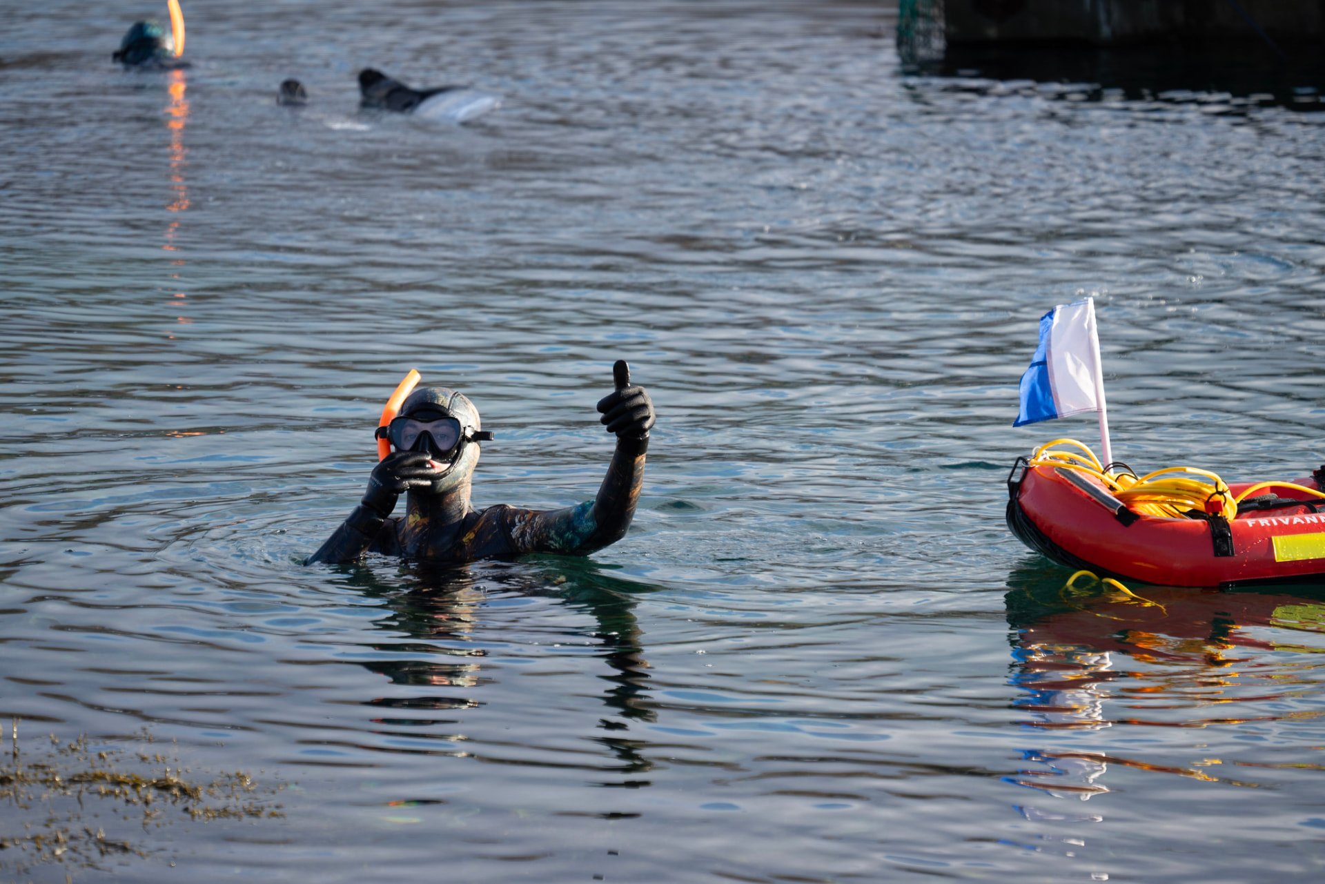 A freediver giving a thumbs-up next to a Frivannsliv dive buoy. Photo: Frivannsliv