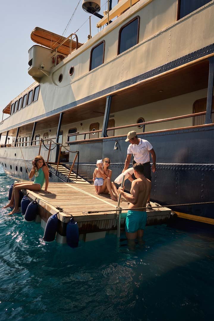 Guests stepping onto Seagull II's floating swim platform