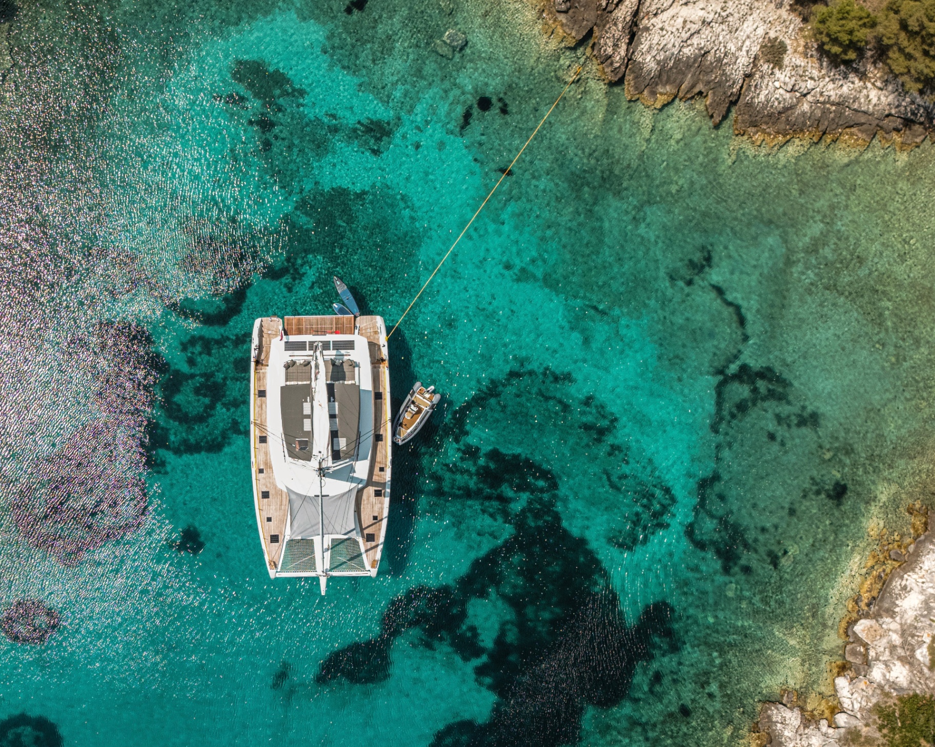 A yacht anchored in a turquoise Dalmatian cove seen from the air