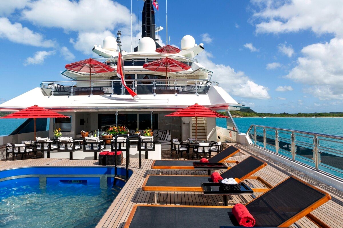 Alfa Nero's pool deck and sunloungers under red parasols. Photo: Fraser