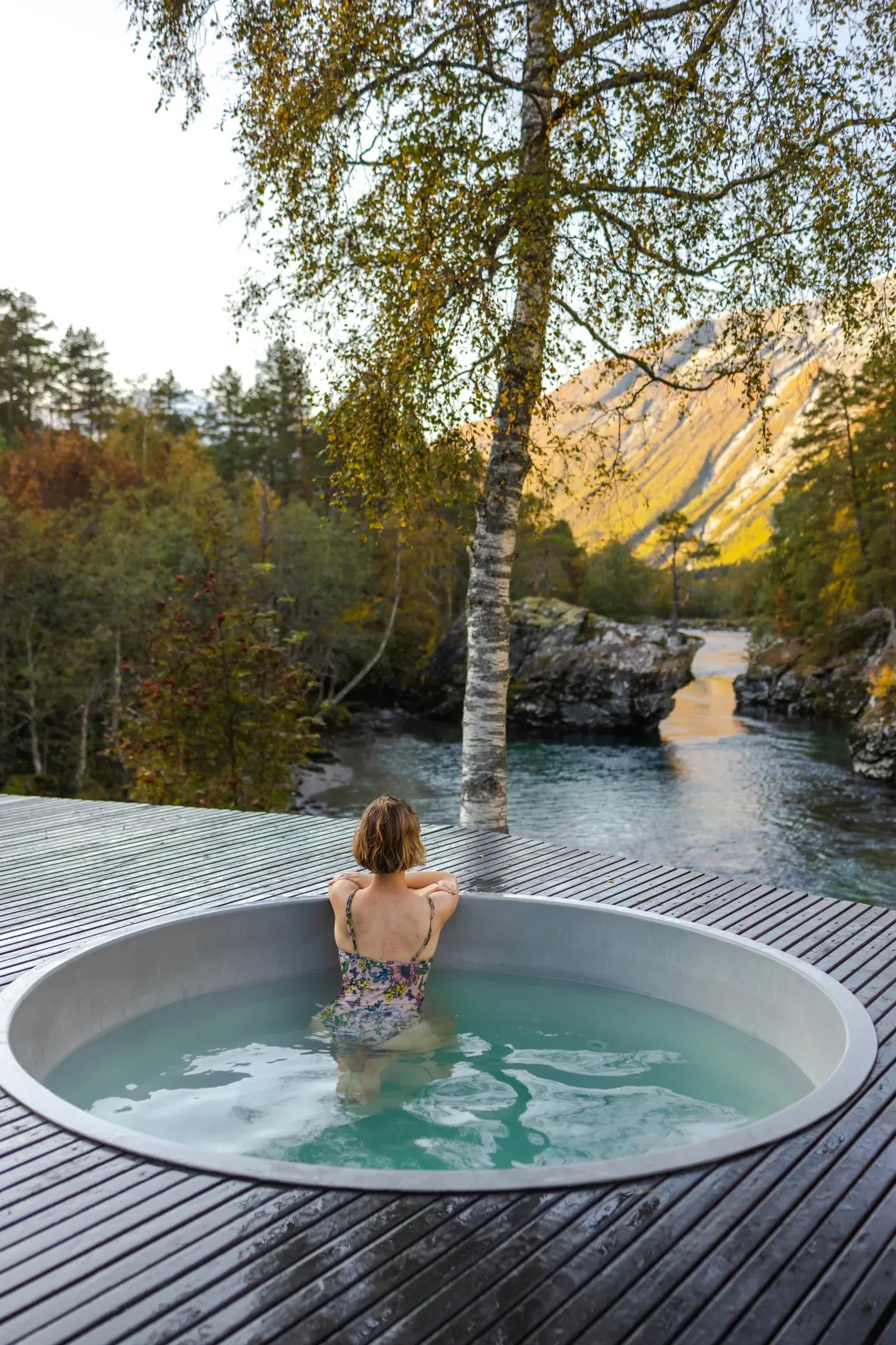 A guest in Juvet's outdoor hot tub overlooking the river. Photo: Juvet Landscape Hotel