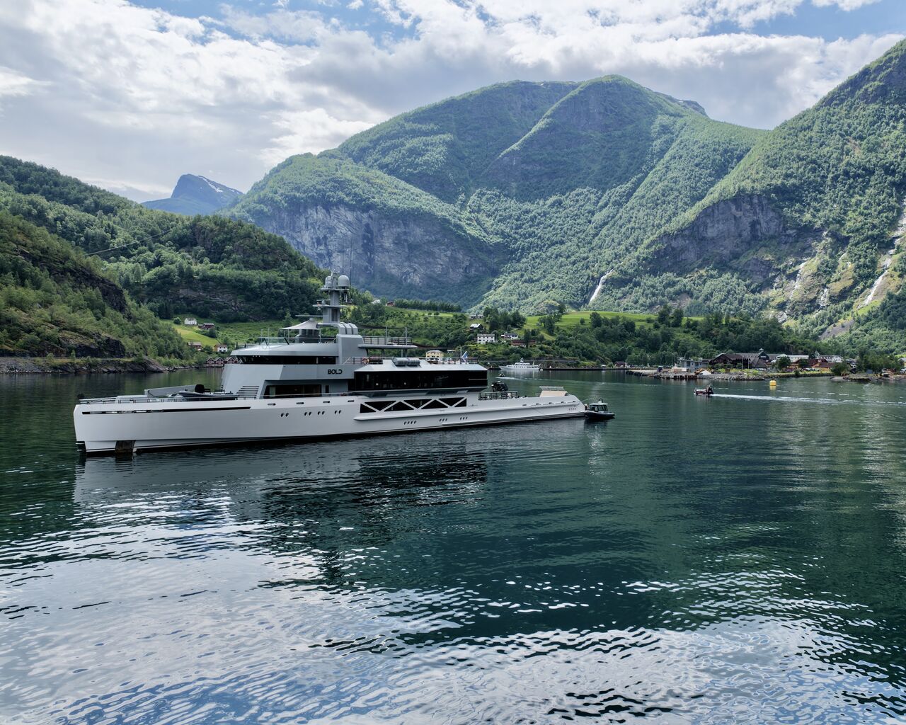 M/Y Bold at anchor in the fjord at Flåm beneath green mountains